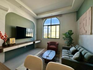 a living room with a couch and a tv at Meridian apartment service at Marina Long beach Phu Quoc in Phú Quốc
