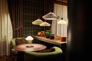 a room with a table and a chair and lights at Les Suites – Maison Bouvier in Tignes