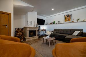 a living room with a couch and a fireplace at Alojamento Jasmine in São Pedro de Alva