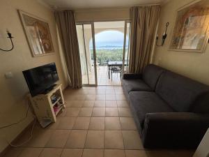 un salon avec un canapé et une télévision dans l'établissement les Restanques Du Golf de Saint Tropez, 83310 Grimaud, France Appartement, à Grimaud