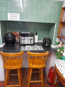 a kitchen with two chairs at a kitchen counter at sark guest house in Barnstaple