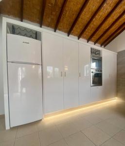 a kitchen with white cabinets and a refrigerator at The Bungalow Kyrenia North Cyprus in Ayios Ioannis +49 photos