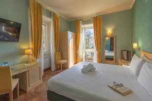 a bedroom with a large bed and a desk and window at LVG Hotel Collection - Belvedere San Gottardo in Verbania +239 photos