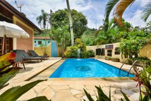 a swimming pool in the backyard of a house at Pousada Estalagem Casa Grande in Ubatuba