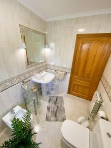 Un baño con lavabo, inodoro y espejo. en Mimosa Ferienhaus, en Cumbre del Sol