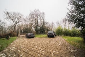 two cars parked in a brick parking lot at Pool Village House Breznica in Brežnica