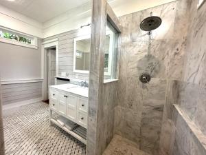 a bathroom with a shower and a sink at Lemon Street Retreat Renovated 1920 Craftman ,Half mile Stroll to Historic DT ,Beaches 3 mi to Vilano & 5 to St Aug in Saint Augustine +33 photos