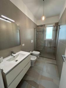 ナルドにあるLungomare Santa Caterinaの洗面台、トイレ、鏡のあるバスルーム +14枚の写真