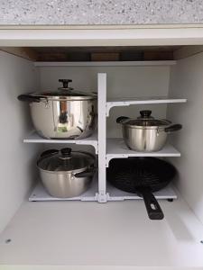 two pots and pans on shelves in a kitchen at With US 2 in Seoul