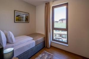 a bedroom with a bed and a large window at Zlatibor Residence & Suites in Zlatibor +21 photos