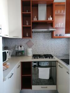 a kitchen with white cabinets and a stove top oven at Milan Top-Floor Flat City View 2 Balconies Workspace M5 in Milan