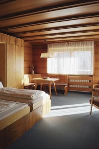 a bedroom with two beds and a table and a window at Belpra in Ortisei