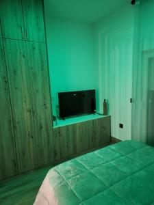 a bedroom with a bed and a flat screen tv at La casita de Nori in León