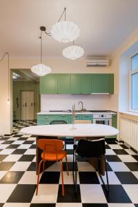 a kitchen with green cabinets and a table and chairs at Downtown Calea Victoriei 100 Jacuzzi&Sauna&Bathtub in Bucharest