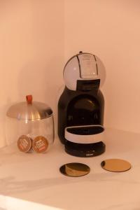 a black coffee maker and a bowl on a counter at Suite Hammam Love Luxe paisible in Les Pavillons-sous-Bois