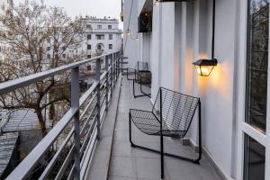a balcony with chairs and a light on a building at Downtown Calea Victoriei 100 Jacuzzi&Sauna&Bathtub in Bucharest
