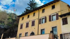 ein gelbes Gebäude mit einer Flagge auf dem Dach in der Unterkunft Sottocastello 2 in Gorizia