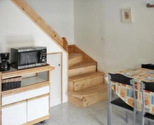 a living room with a microwave and a staircase at Maison charmante à Poggio-Mezzana avec vue mer in Poggio-Mezzana +5 photos