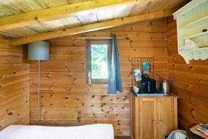 a bedroom with wooden walls and a window at Cabane Perchée avec Jacuzzi, au Coeur du Luberon in Oppède