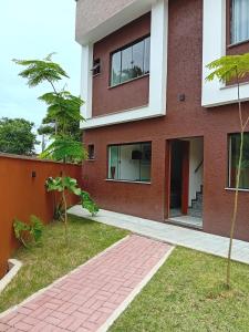 ein rotes Backsteinhaus mit einem Backsteinsteg in der Unterkunft Casa 01 Praia de Paúba-Maresias in Pauba