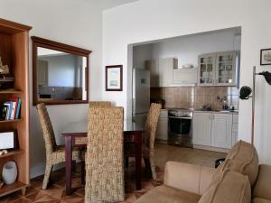a living room with a table and chairs and a kitchen at Apartment Casa sul Mare in Tivat
