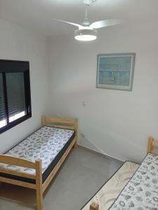 ein Schlafzimmer mit zwei Betten und einem Deckenventilator in der Unterkunft Casa 01 Praia de Paúba-Maresias in Pauba