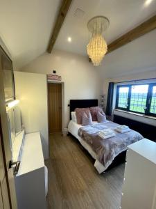a bedroom with a large bed and a chandelier at Sunset Cottage in Warwick