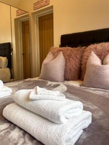 a pile of towels sitting on top of a bed at Sunset Cottage in Warwick +30 photos