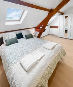 une chambre avec un lit avec des draps blancs et une fenêtre dans l'établissement Grand Jardin Maison Spacieuse Idéale pour Famille, à Larche