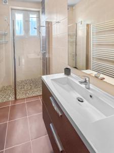 une salle de bain avec un lavabo blanc et une douche dans l'établissement Grand Jardin Maison Spacieuse Idéale pour Famille, à Larche 20 autres photos