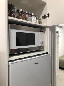 a microwave on top of a refrigerator in a kitchen at La Casilla del Molino in Almodóvar del Río