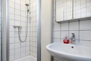 un bagno bianco con lavandino e doccia di Ferienwohnung Vita Burg auf Fehmarn a Burg auf Fehmarn Altre 18 foto