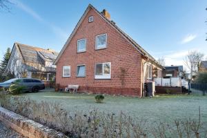 una casa di mattoni con una macchina parcheggiata di fronte di Ferienwohnung Vita Burg auf Fehmarn a Burg auf Fehmarn