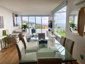 a living room with a glass table and chairs at Vila Da Luz Calheta in Estreito da Calheta