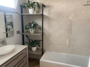 a bathroom with a tub and a shower with potted plants at Vila Da Luz Calheta in Estreito da Calheta +20 photos