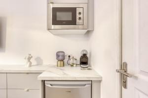 a white kitchen with a microwave and a counter at Suite Love Hammam et Sauna in Les Pavillons-sous-Bois