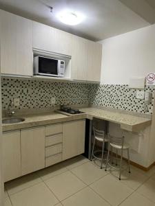 a kitchen with a sink and a microwave at Top Flat confortavel e muito bem localizado in Brasília
