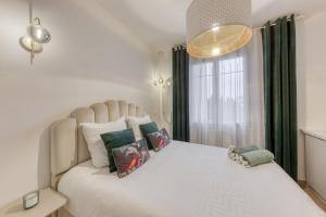 a bedroom with a large white bed with a window at Suite Love Hammam et Sauna in Les Pavillons-sous-Bois