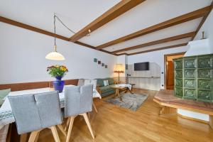 a dining room and living room with a table and chairs at Hotel Garni Tirol in Walchsee