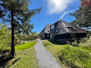 a house with a thatched roof and a gravel path at Bosch (10p) in Buren
