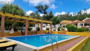 a swimming pool in a backyard with a pergola at Casal do Varatojo in Alcobaça