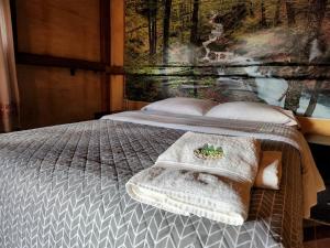 a bed with a blanket and towels on it at Rancho San Miguel in Villa del Carbón