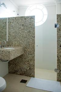 a bathroom with a shower and a sink and a toilet at Lider Hotel Ituiutaba in Ituiutaba