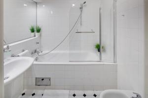 a white bath tub sitting next to a white sink at Charles Bridge Premium Apartments in Prague