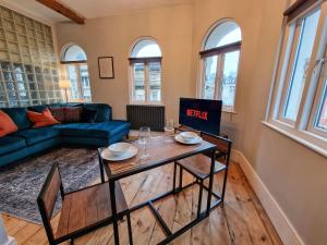 a living room with a blue couch and a table at City Centre Manchester Apt by City SuperHost in Manchester