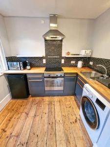 a kitchen with a washing machine and a sink at City Centre Manchester Apt by City SuperHost in Manchester