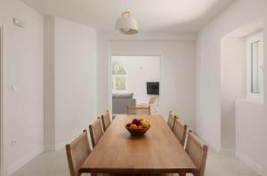 a dining room with a wooden table with a bowl of fruit at Villa Magic Stone in Šišići