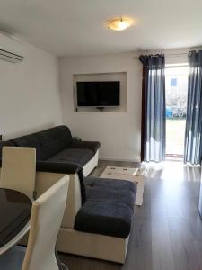 a living room with a couch and a tv at Apartment Maria in Pirovac