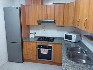 a small kitchen with a refrigerator and a sink at Apartment La Huerta de Beniajan 50 por ciento dcto directo in Murcia
