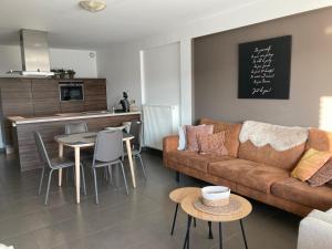 a living room with a couch and a table at miroir de la mer in Blankenberge